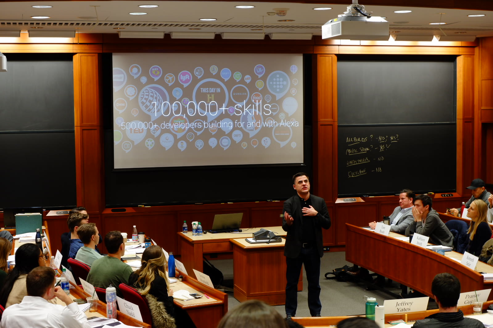 Dave Isbitski speaking to Harvard Business School students beneath a slide showing more than 100,000 Alexa skills and 500,000 developers