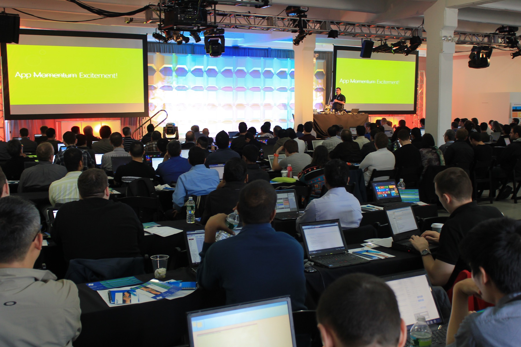 A large room of developers with laptops watching Dave Isbitski present Windows 8 on stage in New York City