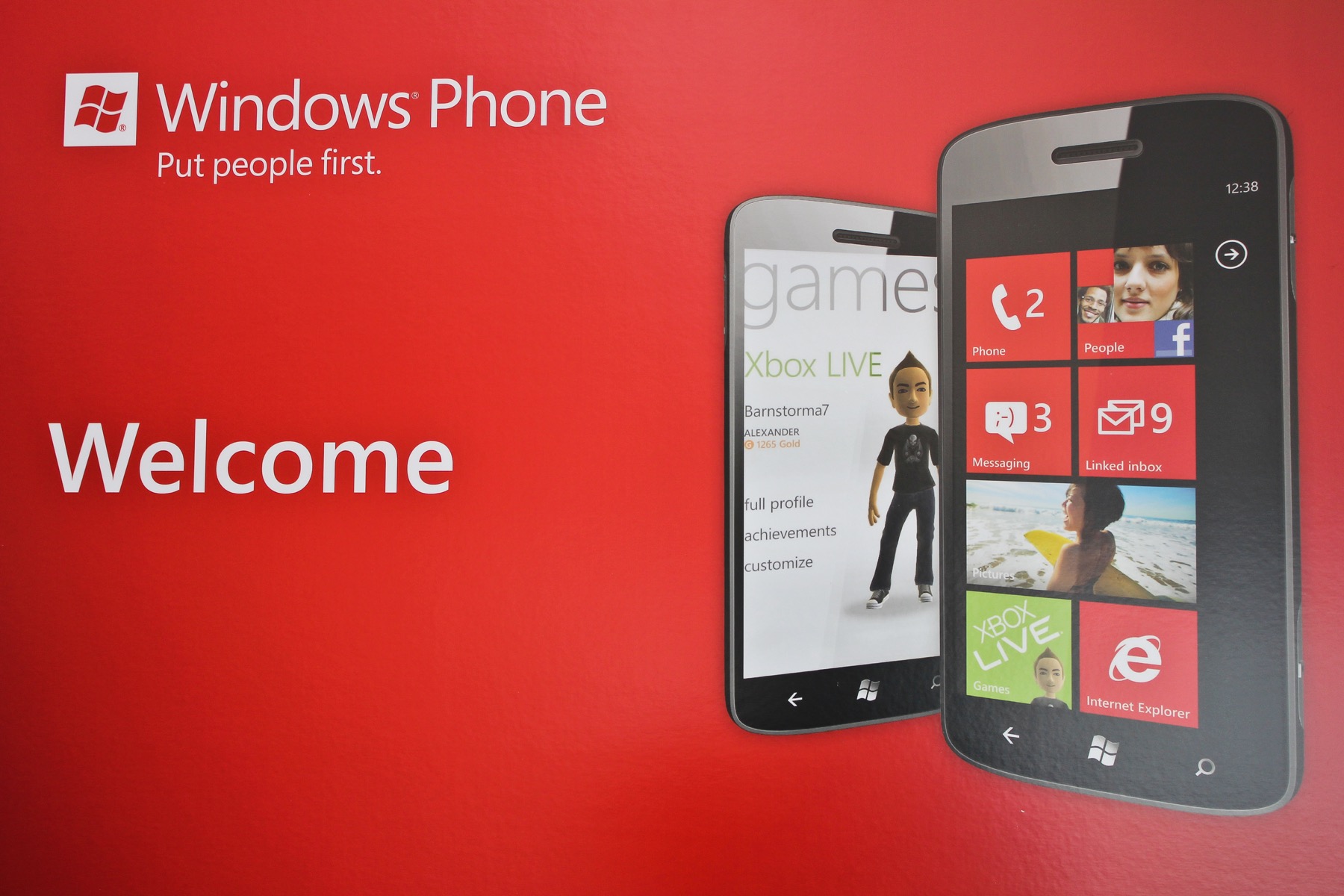 Red Windows Phone welcome display with two phones and the Put people first tagline at the Boston hackathon